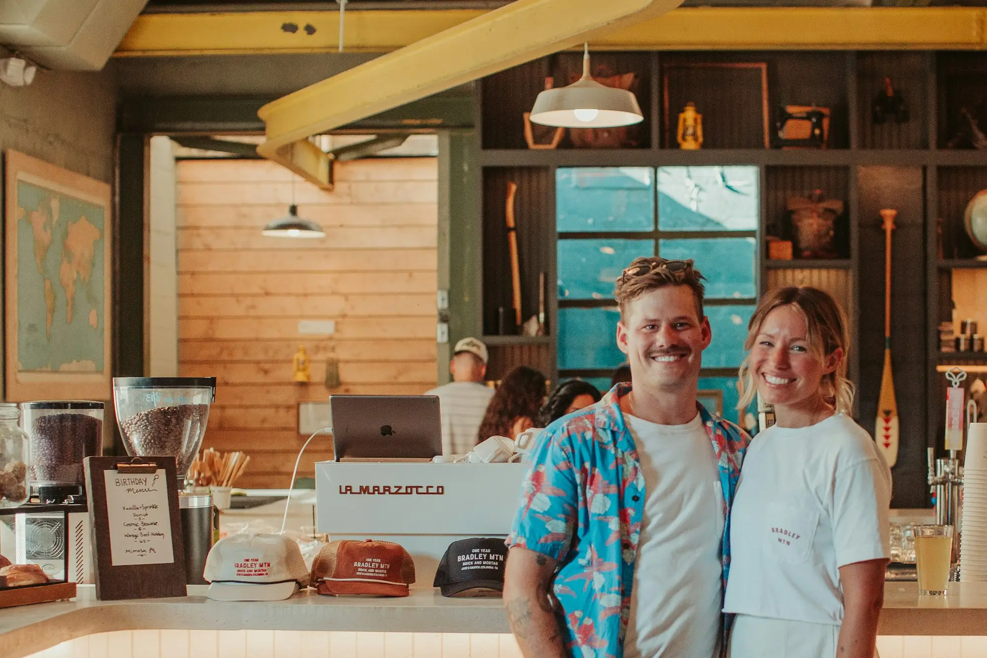 Two cafe owners standing proudly in their cafe