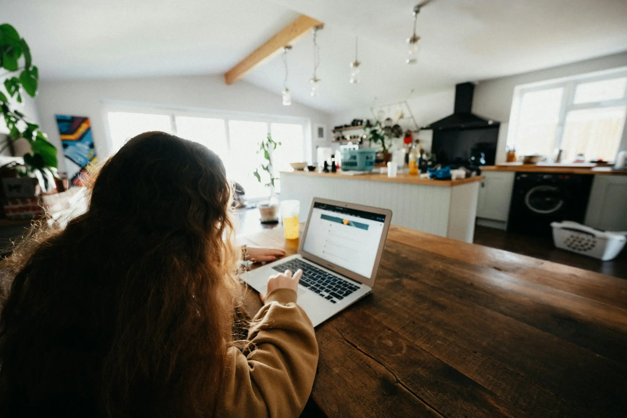 Business owner working on a laptop at the kitchen table